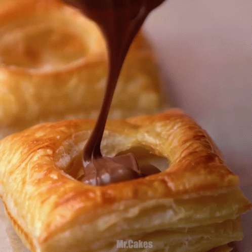Chocolate Is Being Poured Into A Pastry That Says Mr.cakes On It GIF