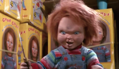 Chucky Doll Holding Scissors Beside Stack of Chucky Dolls