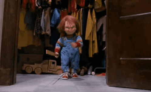 Chucky Doll Sitting on Ladder Holding Stick