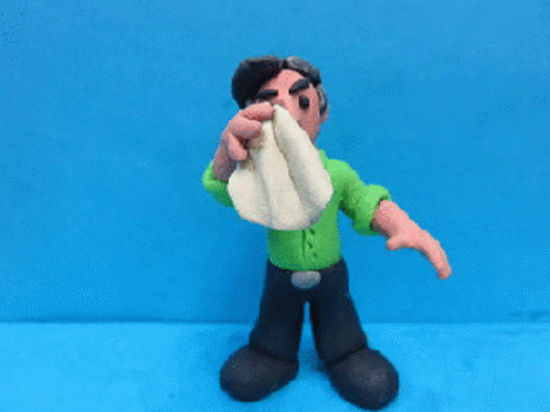 Clay Man in Green Shirt Wiping Nose With Towel