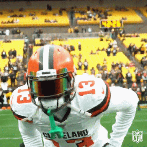 Cleveland Football Player Holding Green Object in Mouth