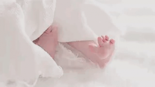 Close Up Baby's Feet on White Blanket