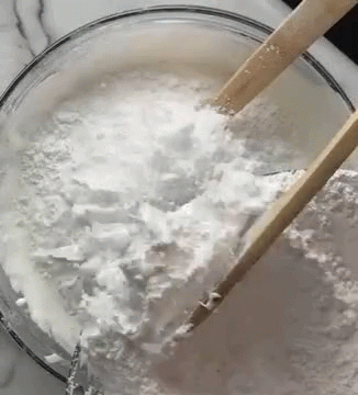 Close Up Bowl of Powdered Sugar with Wooden Spoons