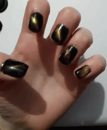 Close Up Hand With Black and Gold Nail Polish