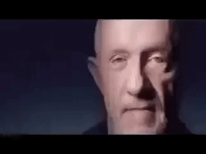 Close Up Man With Beard Looking At Camera In Dark Room GIF