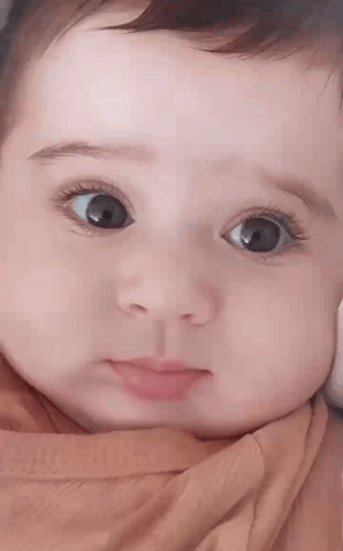 Close Up of Baby With Big Eyes and Pink Shirt