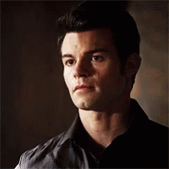 Close Up Of Man's Face In Black Shirt And Vest GIF