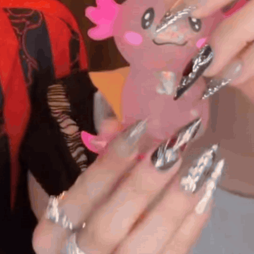 Close Up of Nails Holding Pink Axolotl