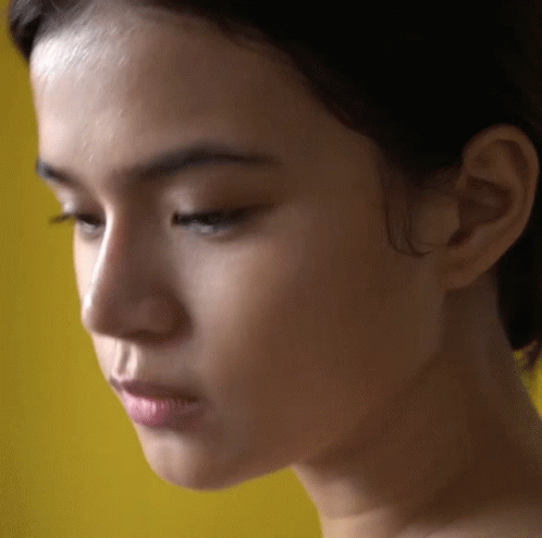 Close Up Woman's Face Against Yellow GIF