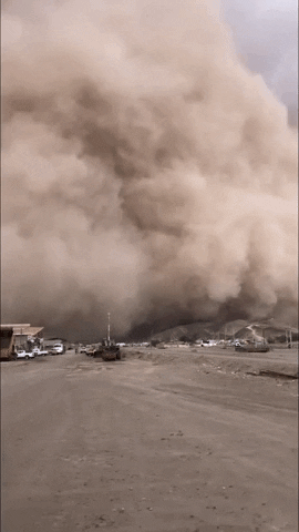 Cloudy Dust Storm Moving Through Houses GIF