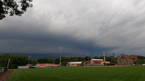 Cloudy Sky Over Baseball Field With Buildings