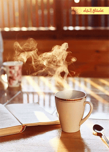 Coffee With Steam Next to Open Book