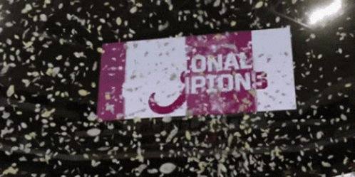 Confetti Thrown in Air With National Champions Sign