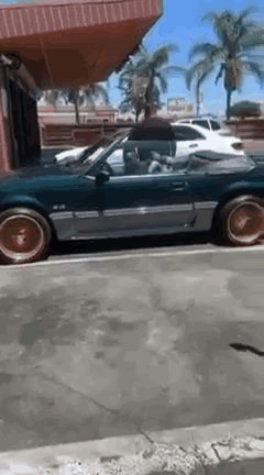 Convertible Mustang Parked Next to Building