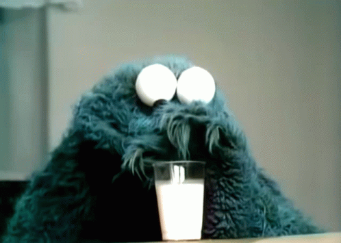 Cookie Monster Drinking A Glass Of Milk With Eggs In His Eyes GIF