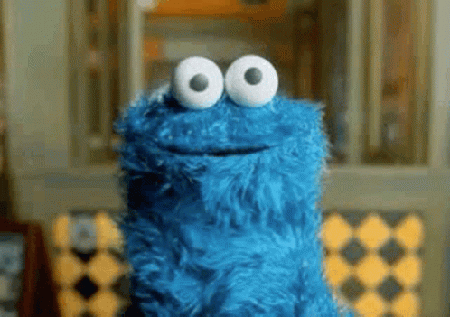 Cookie Monster From Sesame Street Is Smiling And Looking At The Camera With Big White Eyes . GIF