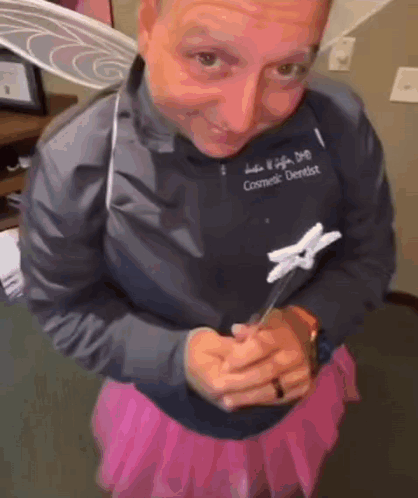 Cosmetic Dentist in Pink Skirt Holding Toothbrush