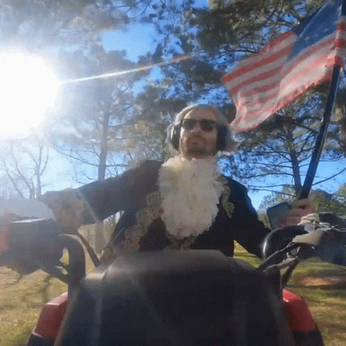 Costumed Man Riding Golf Cart with American Flag