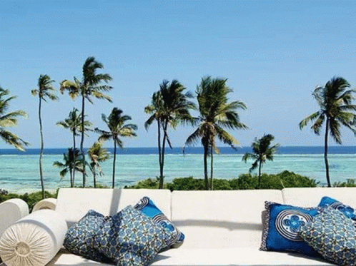 Couch With Blue Pillows On Balcony Overlooking Ocean GIF