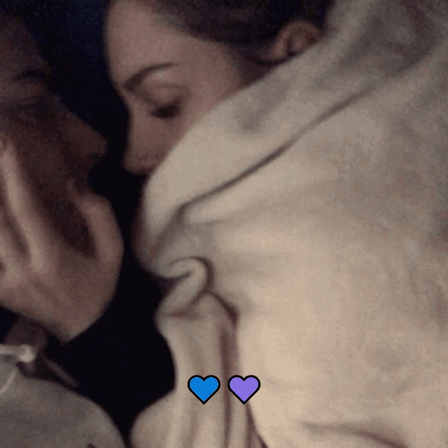 Couple Lying Under Blanket With Blue Hearts GIF