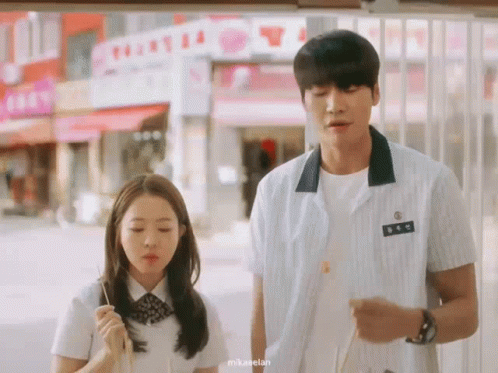 Couple Outside Building with T Sign