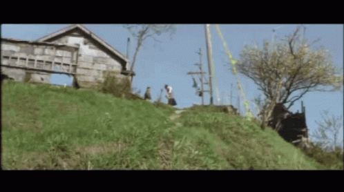 Couple Walking Down Hill In Front Of House GIF