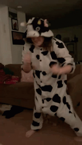 Cow Costume Person Dancing on Brown Couch