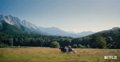 Cow Running in Field with Mountains and Netflix Logo