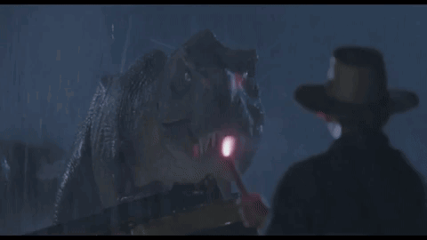 Cowboy Hat Man In Front Of Dinosaur With Flashlight GIF