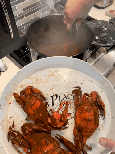 Crabs Are Being Cooked On A Plate That Says " Crab Place " GIF