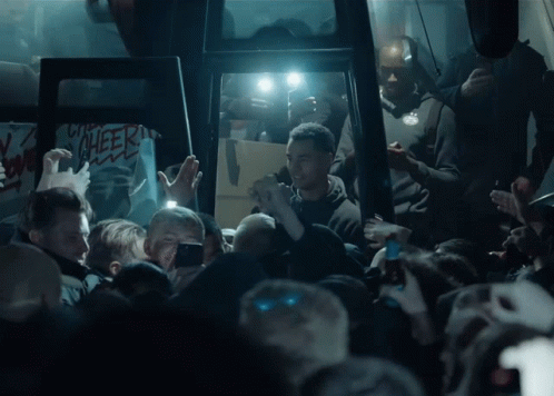 Crowd Gathering in Dark Room Cheer Sign