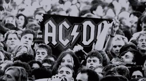 Crowd Holding Sign Saying AC D
