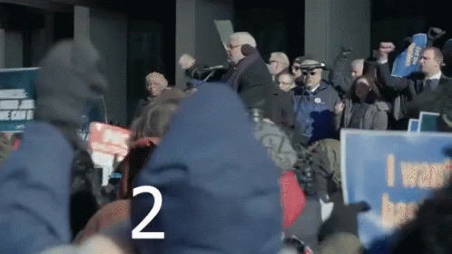 Crowd Holding Signs Including I Want Better
