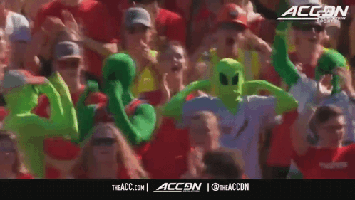 Crowd in Green Alien Costumes With ACCN Logo