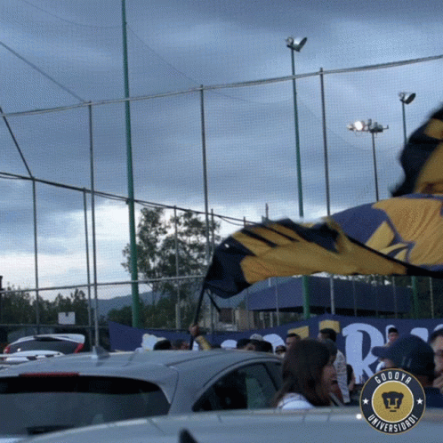 Crowd in Parking Lot With Goodya Universidad Banner