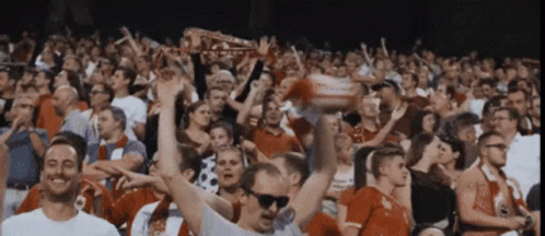 Crowd in Stadium With Man in Sunglasses Holding Liverpool Scarf