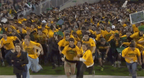 Crowd in Yellow Shirts Cheering Running on Field