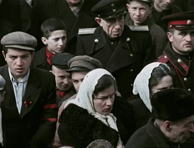 Crowd Including Woman With Scarf And Man With Hat GIF