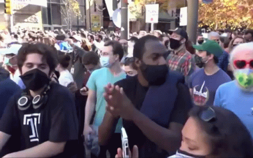 Crowd of People Wearing Face Masks Gathered in Street