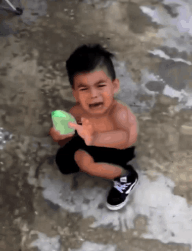 Crying Little Boy Holding Green Object