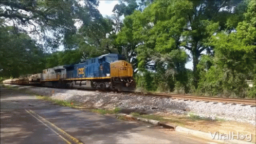 CSX Train Going Down Tracks Near Road