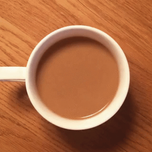 Cup of Coffee on Wooden Table With White Handle