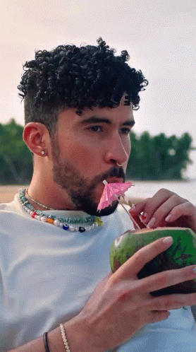 Curly Hair Man Drinking Coconut Pink Umbrella in Mouth