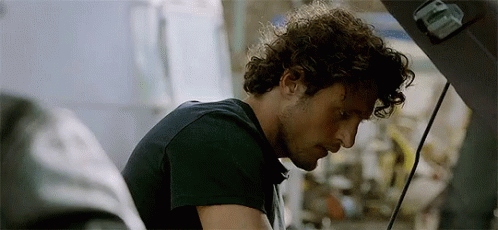 Curly Hair Man Looking Under Car Hood