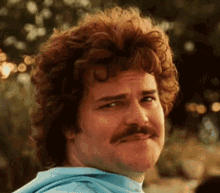 Curly Haired Man in Blue Shirt Making Funny Face
