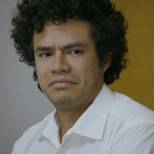 Curly Haired Man Making Serious Face in White Shirt
