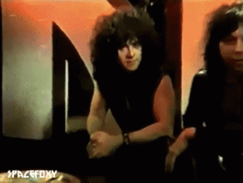 Curly Haired Man Next To Another Man At Spacefoxy Sign GIF
