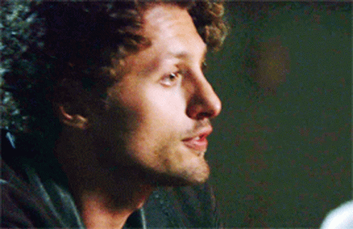Curly Haired Man With Beard Looking To Side