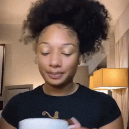Curly-Haired Woman Holding Coffee Making Funny Face