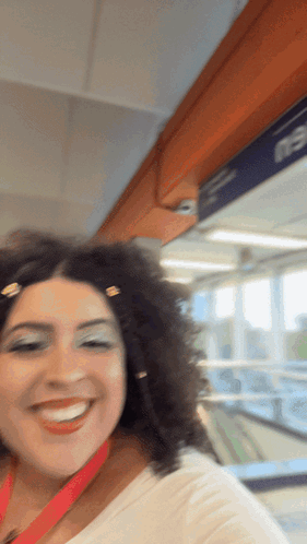 Curly Haired Woman Smiling At E3 Sign GIF